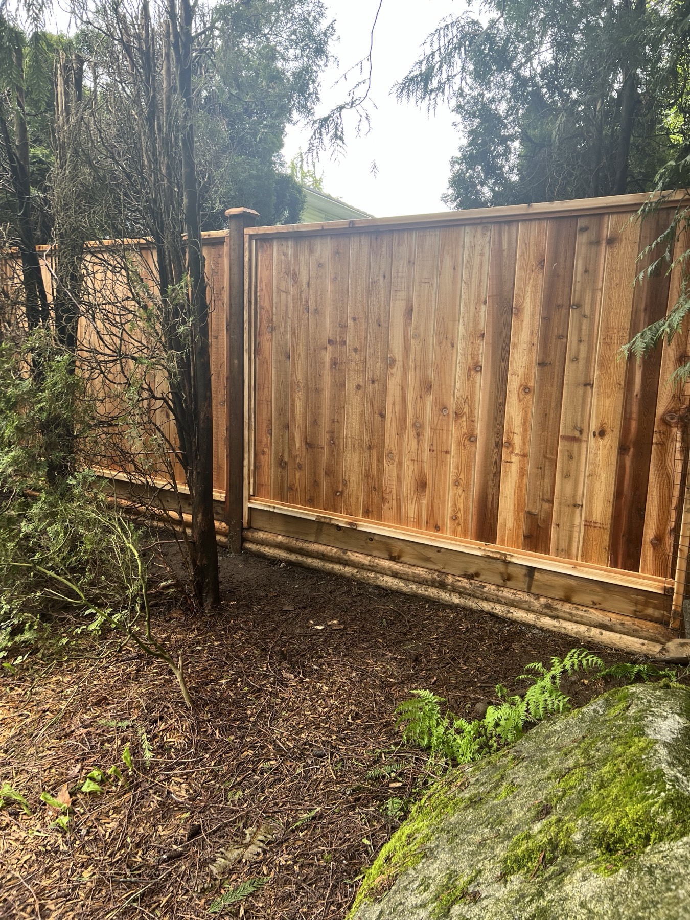 A cedar fence along a garden